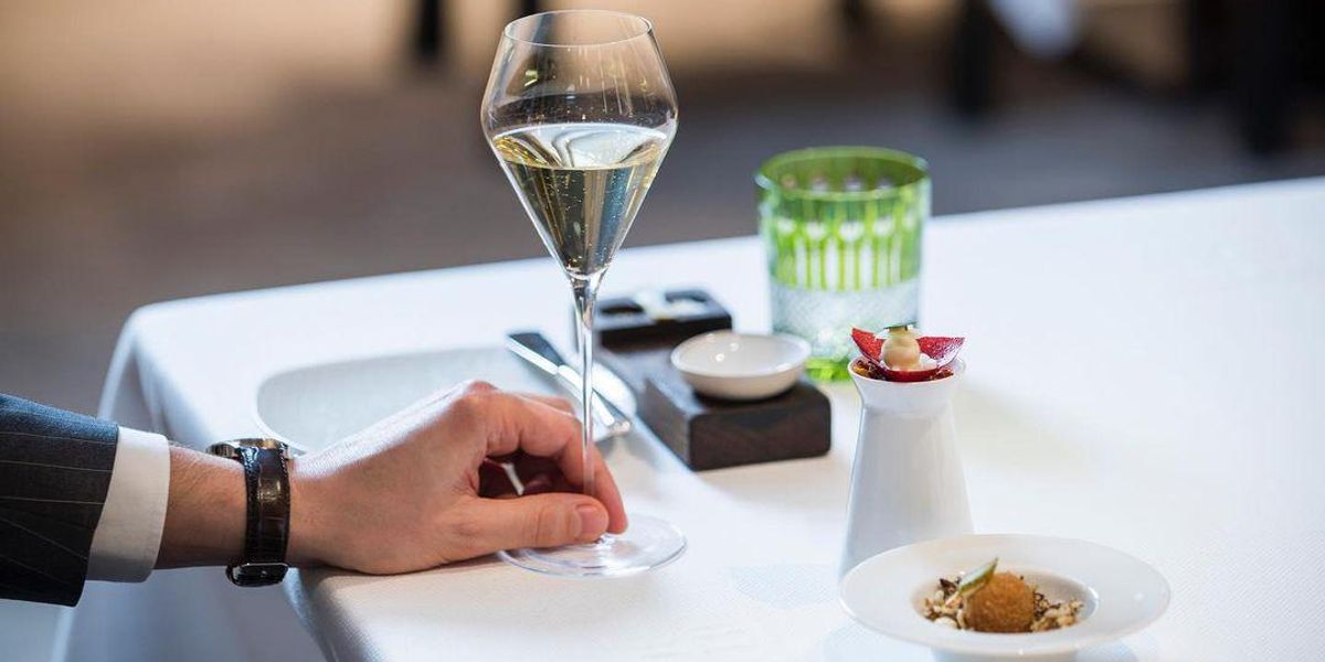 Ciel Bleu Michelin-csillagos étterem asztala egy fogással és egy pohár pezsgővel