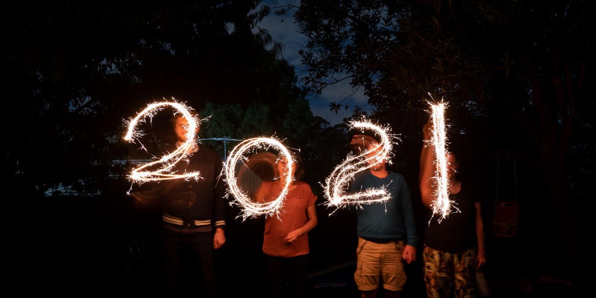 négy ember csillagszórókkal „2021" feliratot rajzol a levegőbe