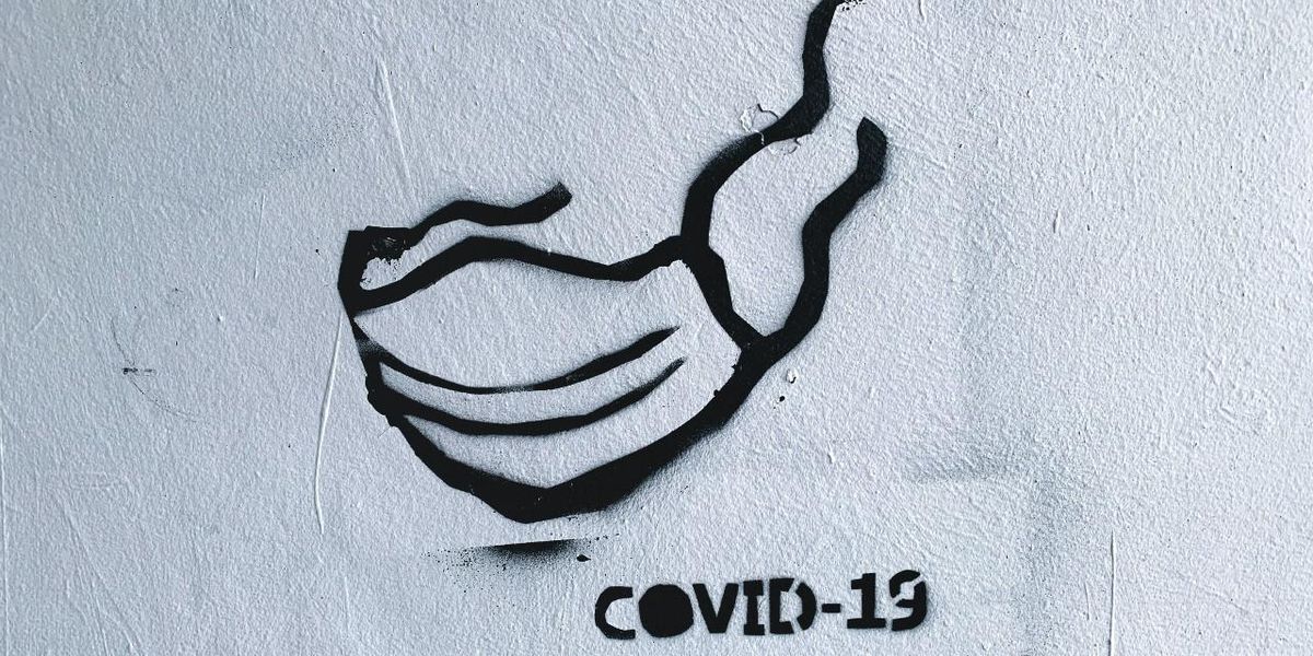 Maszk és COVID-19 felirat egy falra felfestve