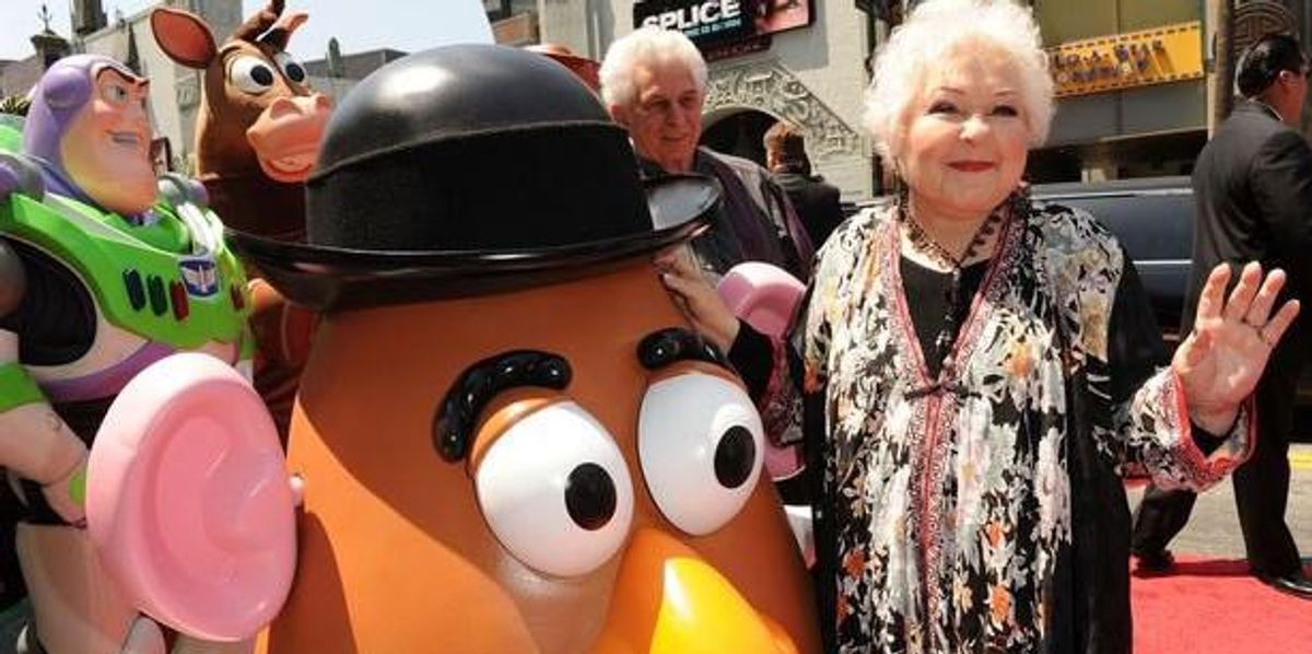 Estelle Harris egy Toy Story figura mellett integet