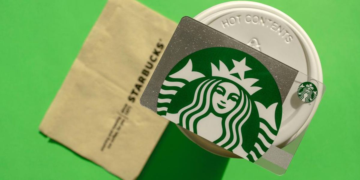 Starbucks ajándékkártya fehér elviteles poháron, szalvétával, zöld háttéren