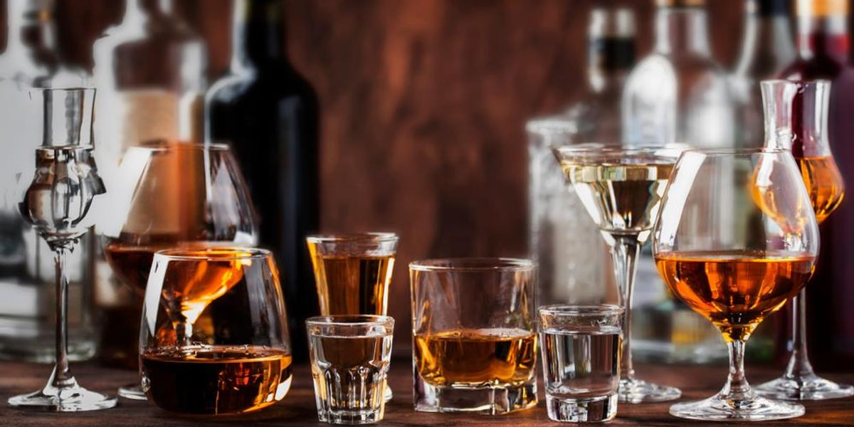Különböző alkoholok: vodka, konyak, tequila, brandy, whisky, grappa, likőr, vermut, rum fa asztalon