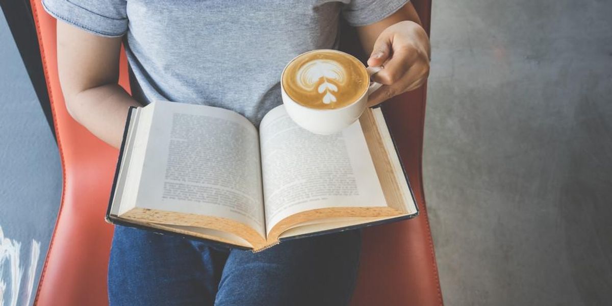 Egy ember kávézás közben olvas