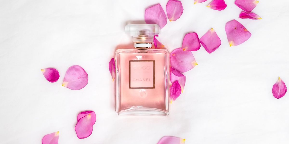 Rózsaszirmok egy parfüm mellett