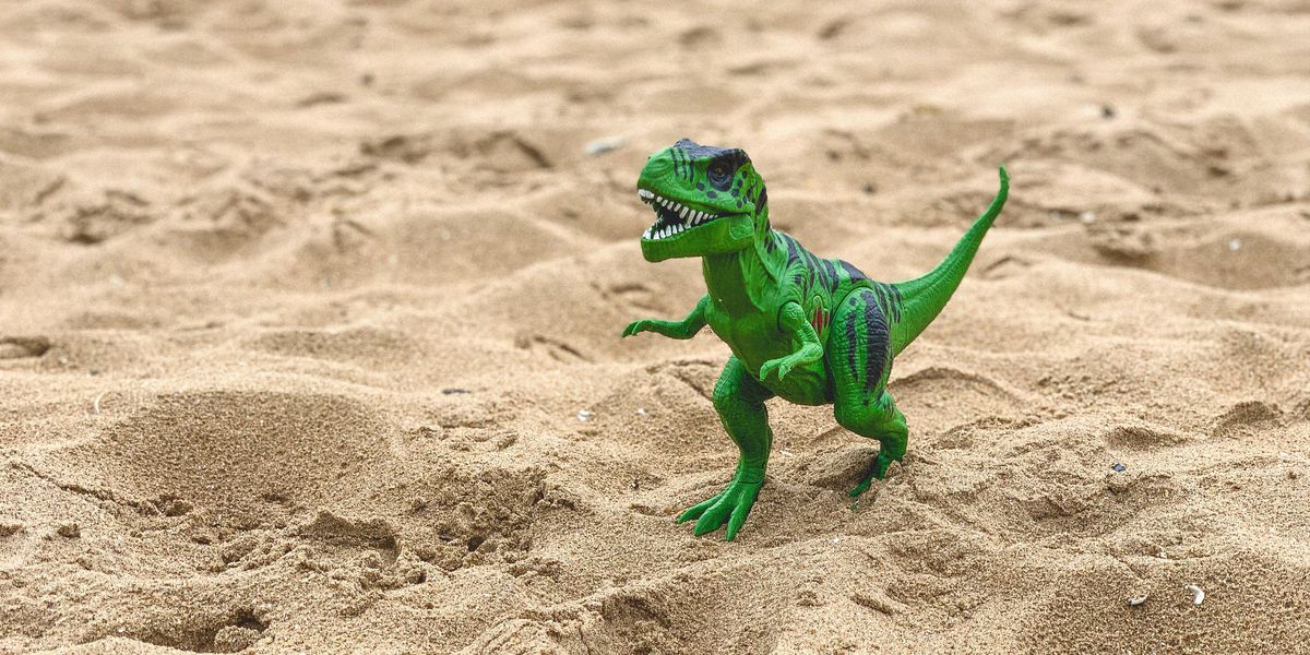 Zöld dinó a homokos parton