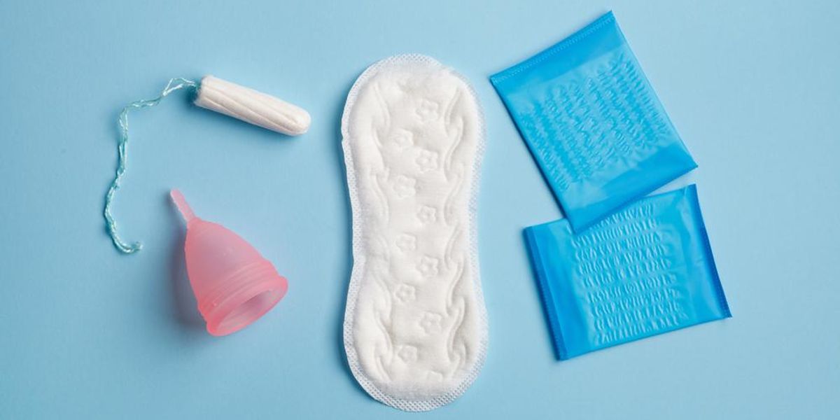 Menstruációs termékek: betétek, menstruációs kehely és tampon, kék háttéren