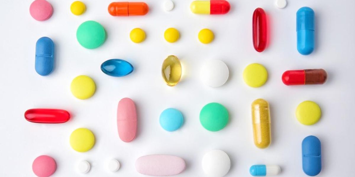 Különböző színes tabletták, fehér háttéren