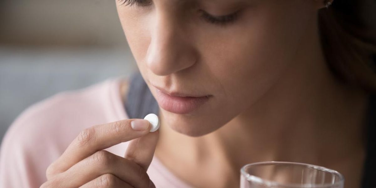 Tablettát bevevő nő