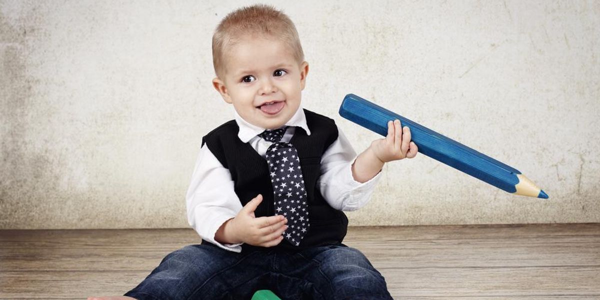 Kisbaba nyakkendővel, kezében nagy színes ceruza