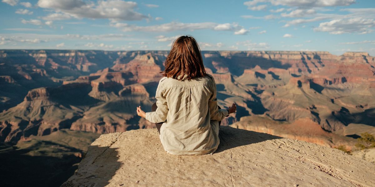 Egy lány meditál a hegy tetején