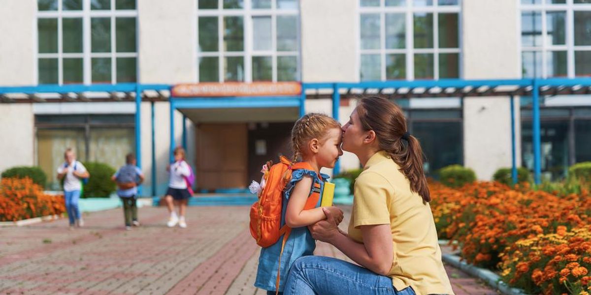 Anyuka a gyerekét puszilja iskola előtt