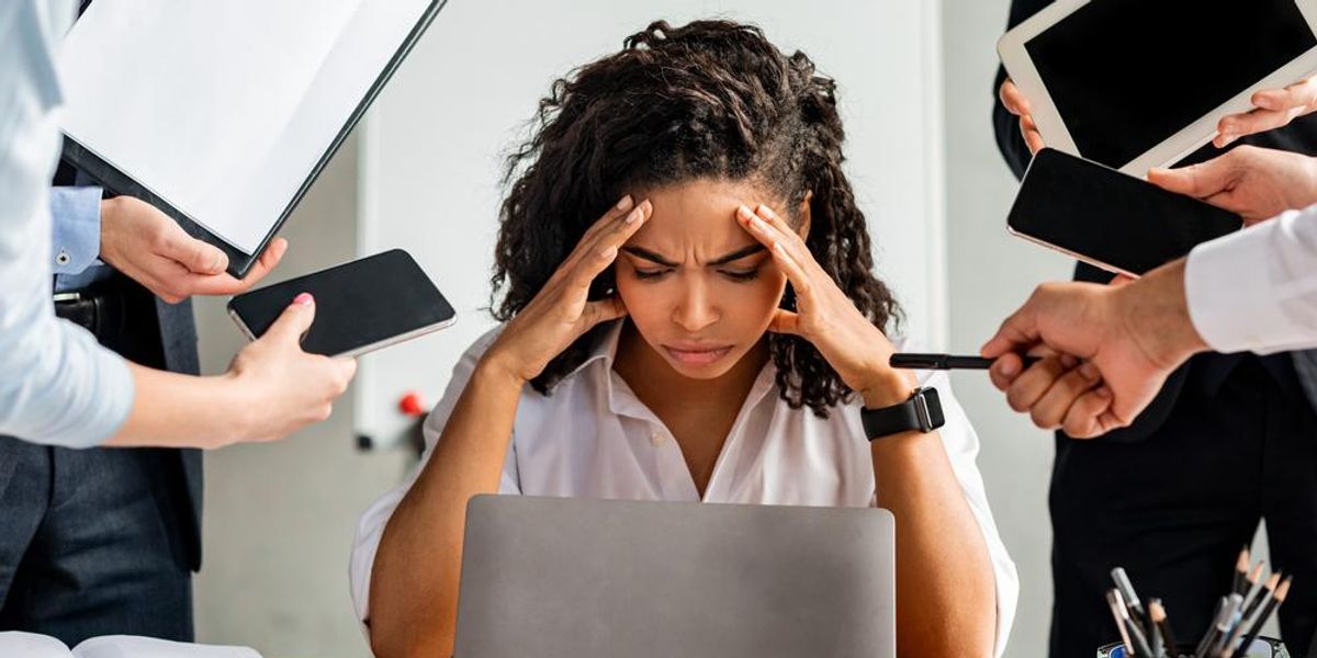 Túlhajszolt nő stresszel a sok feladat miatt a munkahelyén 