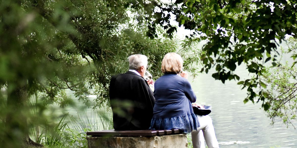 Egy idős pár a patakparton bort iszik