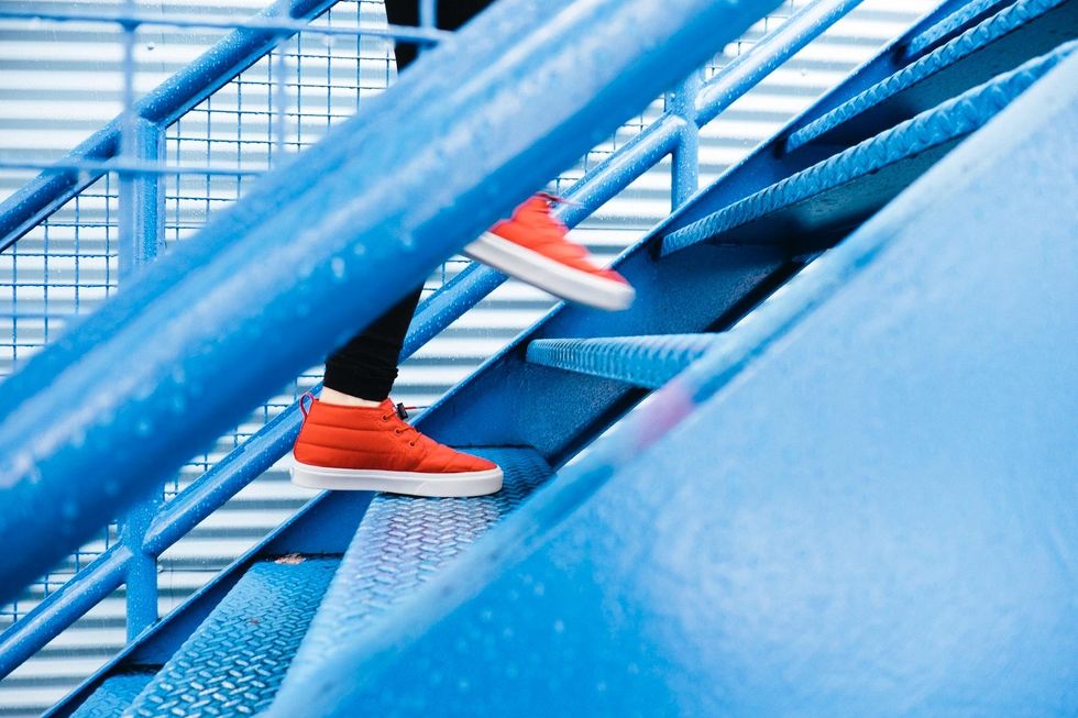 Un hombre con zapatos naranjas sube las escaleras.