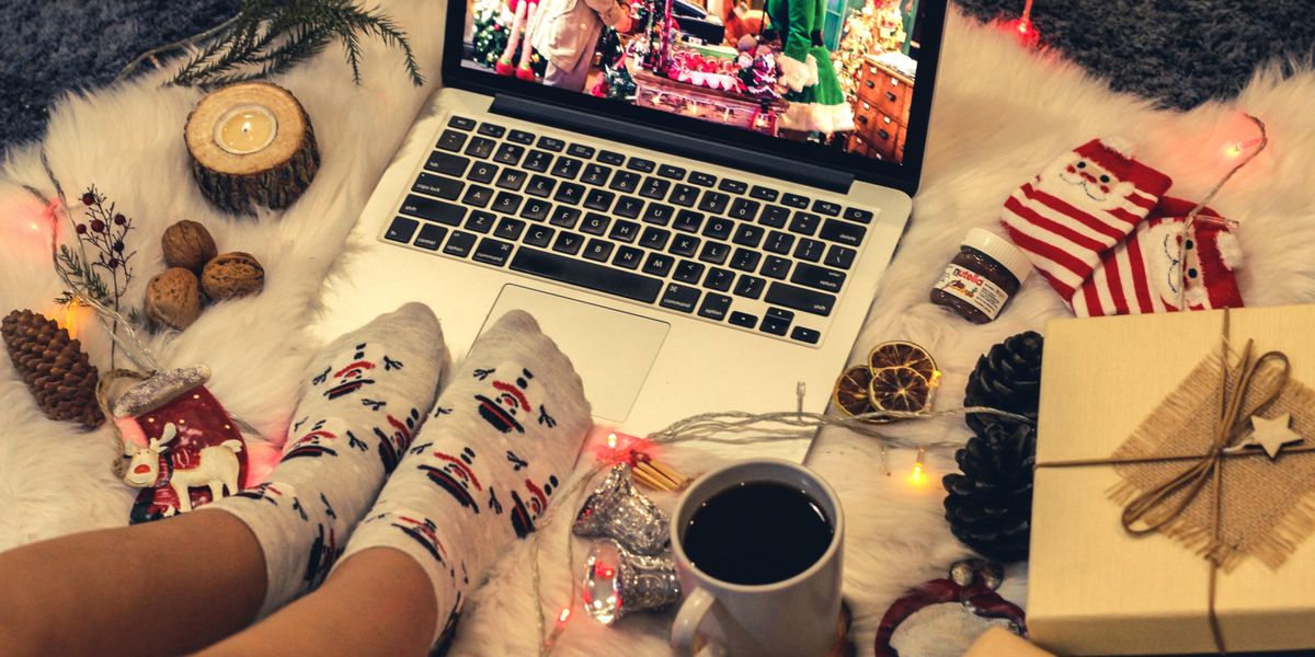 Egy lány karácsonyi díszekkel és tárgyakkal körülvéve ünnepi filmet néz