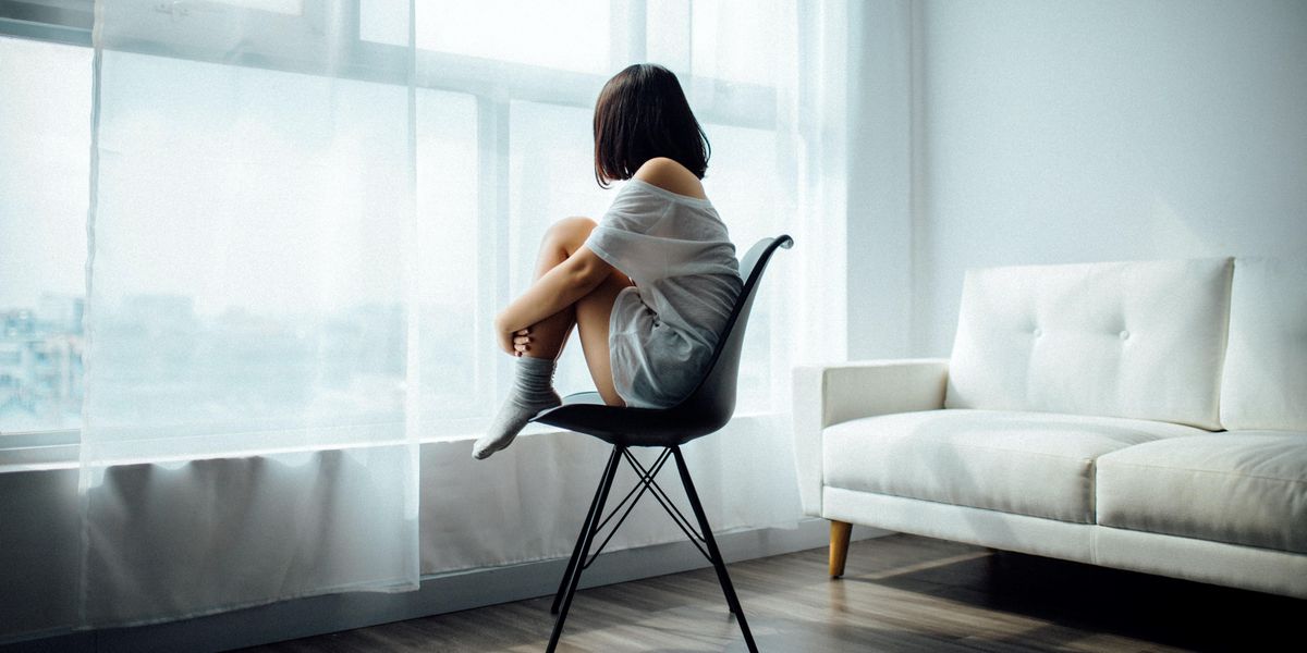 Egy lány egyedül ül a szobájában és néz ki az ablakon