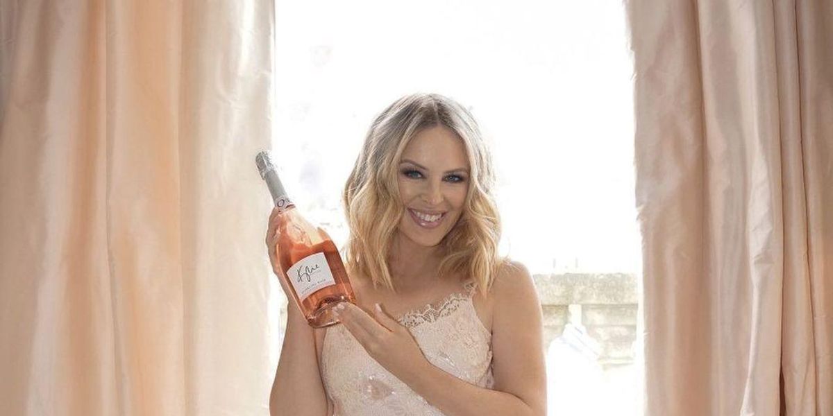 Kylie Minogue saját márkás borát tartja a kezében