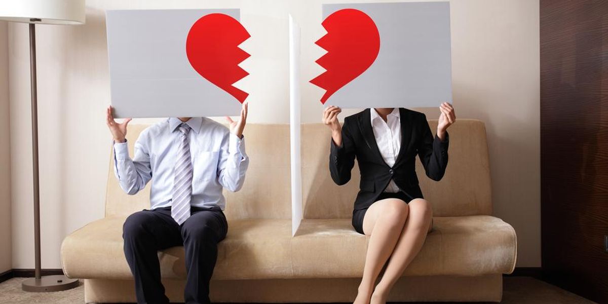 Összetört szív formákat ábrázoló plakátokat tartó férfi és nő