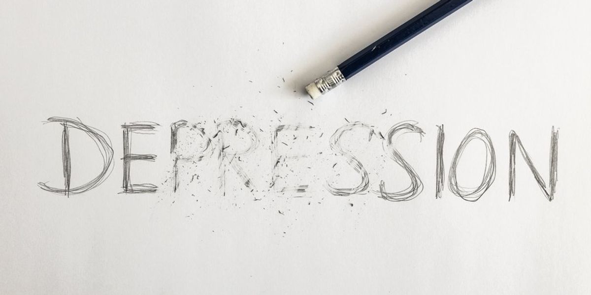 Depresszió szó, fehér papíron, egyes betűi kiradírozva. A depresszió leküzdésének vagy a depresszió kezelésének szimbolikája