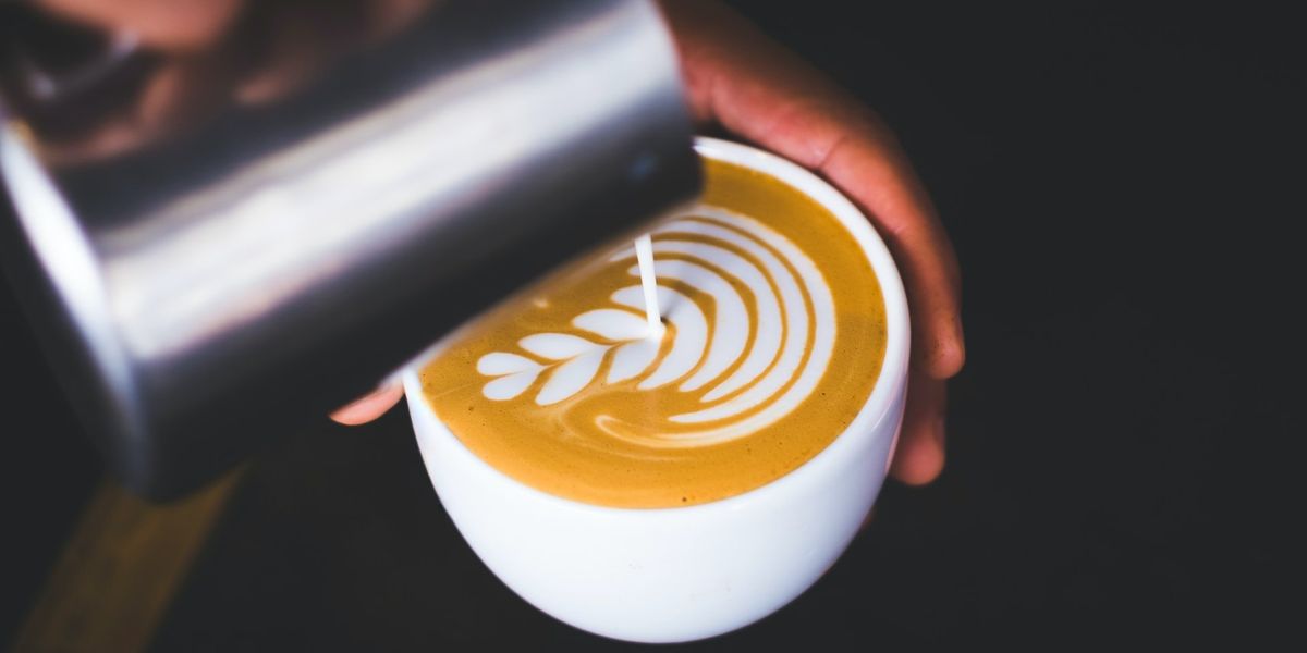 Egy barista latte artot készít egy kávéra