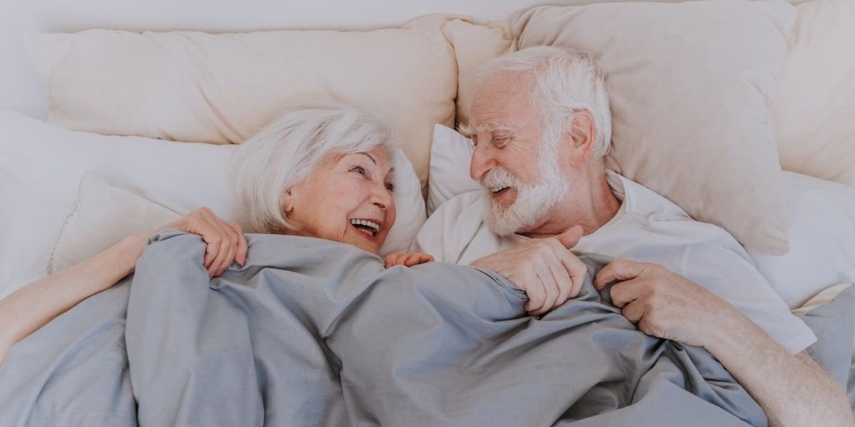 Idősebb pár az ágyban, betekarózva