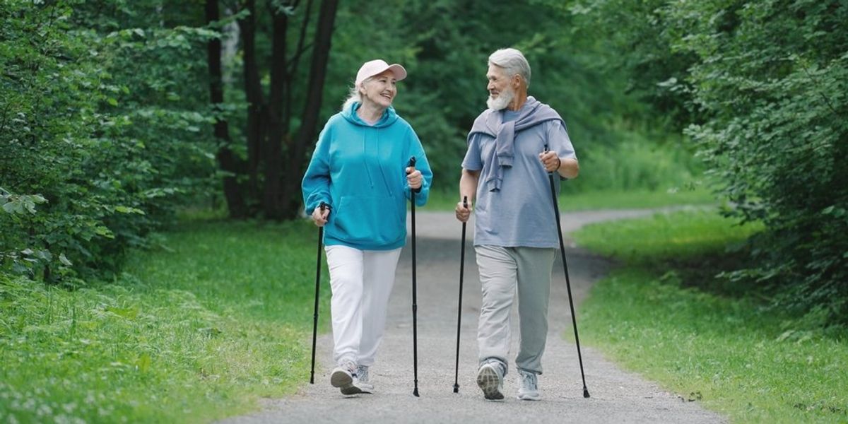Idősebb pár nordic walking közben az erdőben