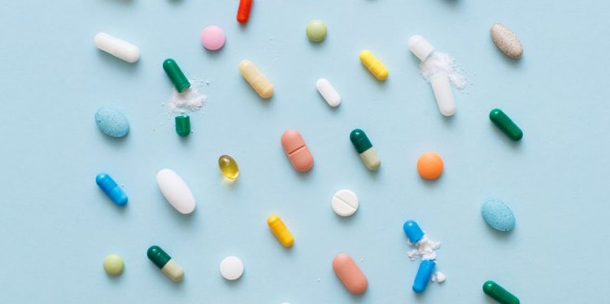 Színes vitaminok és tabletták kék háttéren
