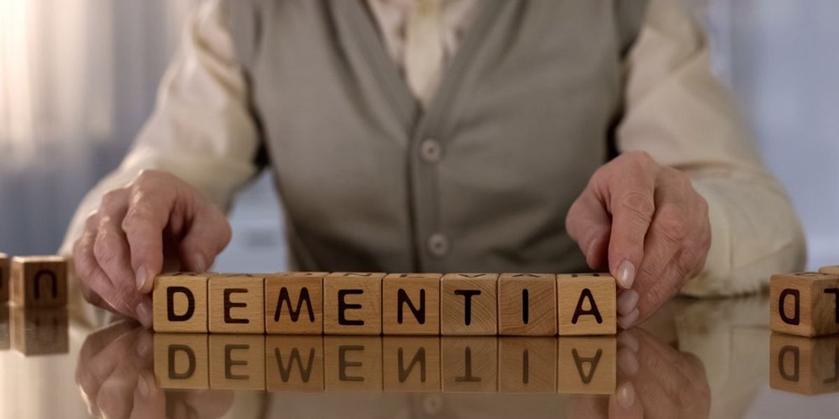 Demencia szót betűkockákból kirakó kéz