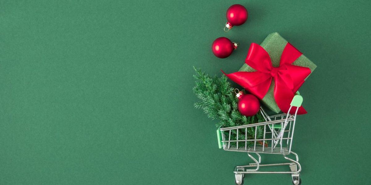 Bevásárlókocsi, benne karácsonyfa, ajándék és karácsonyi díszek