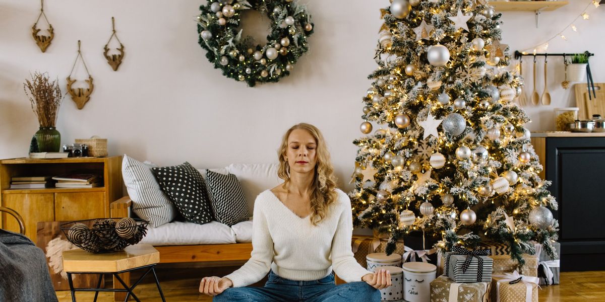 egy nő meditál a karácsonyfa alatt
