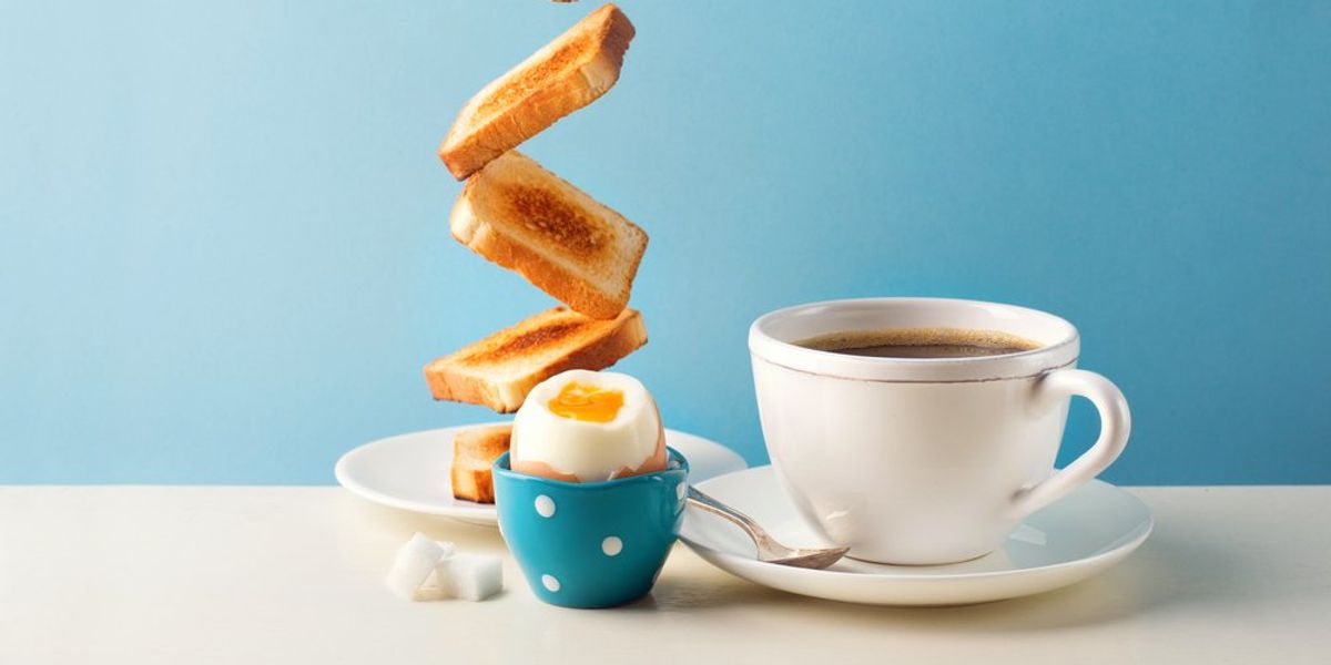 Reggeli lágy tojással, pirítóssal és csésze kávéval, kék háttéren