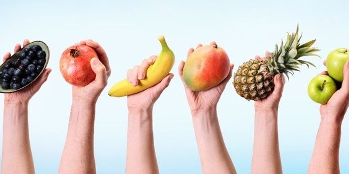 Különböző gyümölcsöket tartó kezek