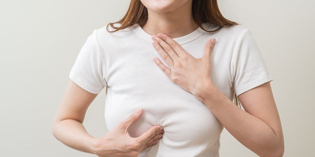 Savas reflux, mellkasára és gyomrára kezeit rátevő nő