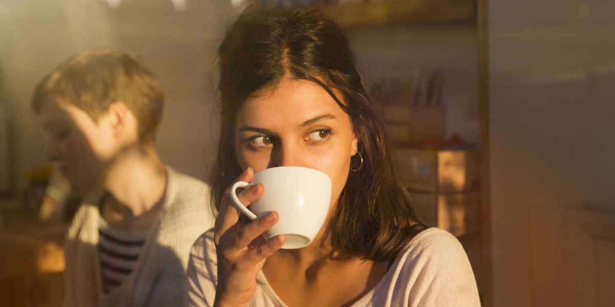 egy nő kávét iszik egy kávézóban a napsugarakban