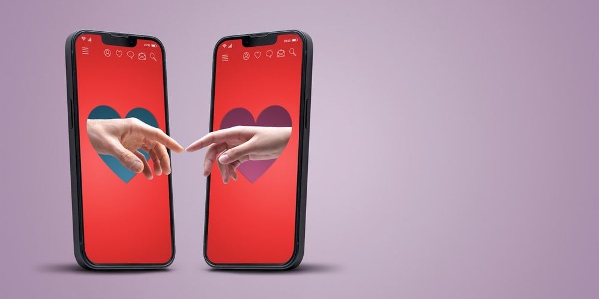 Két mobilból egymás felé nyúló kezek - online társkereső