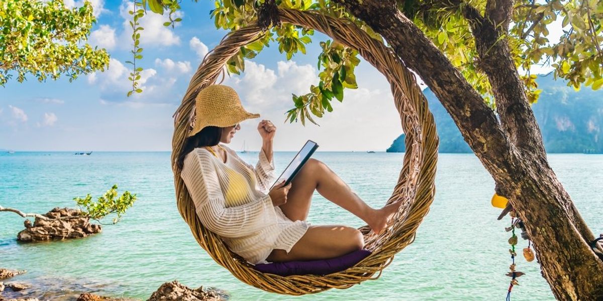 Függőhintában olvasó nő a tengerparton