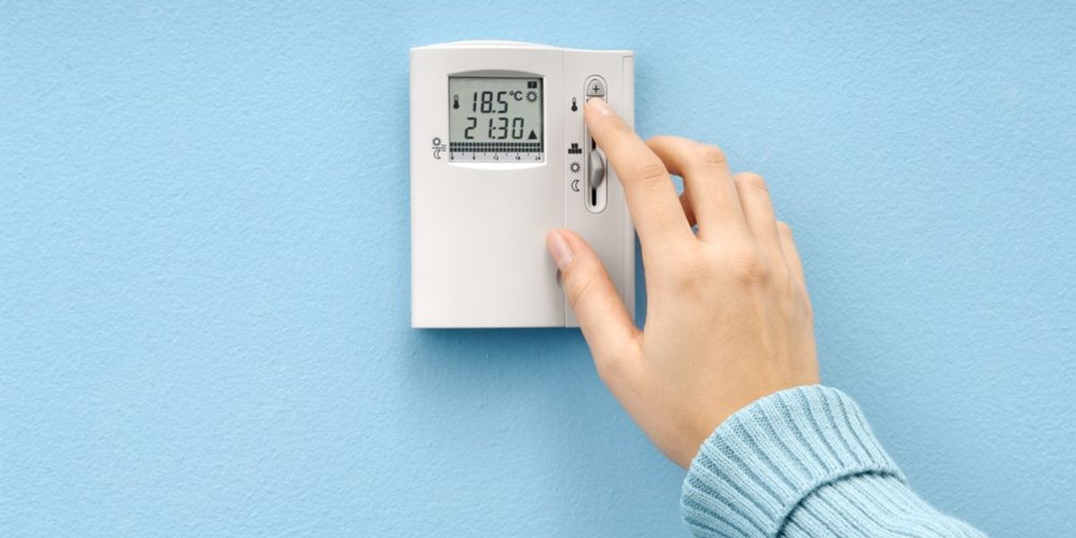 Szobahőmérséklet-szabályozás termosztáttal, női kéz