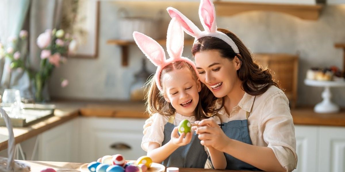 Fiatal anyuka a lányával díszíti a húsvéti tojásokat