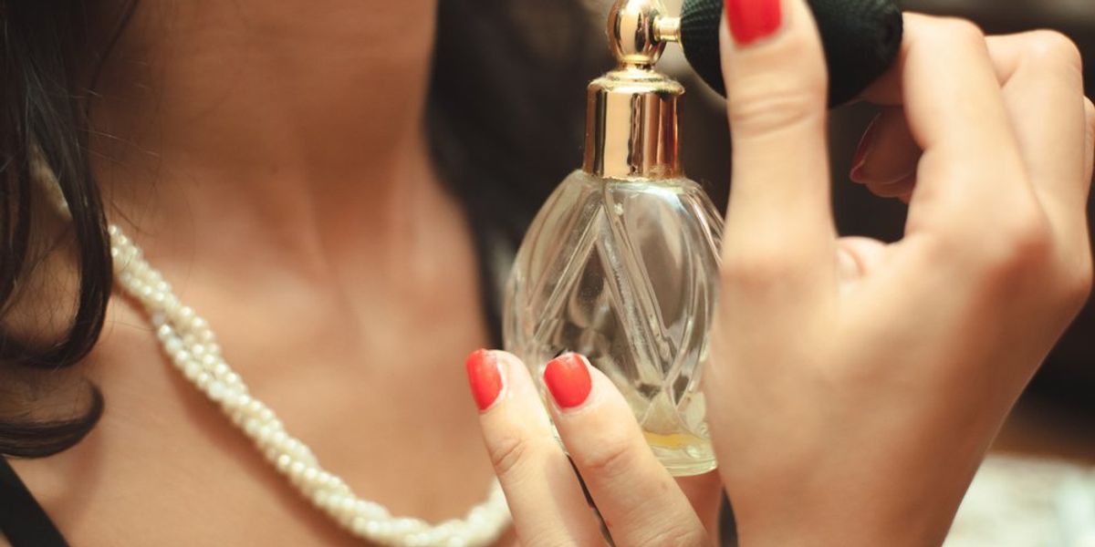 egy nő parfümöt fúj magára