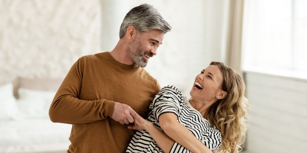 egy boldog férfi és nő együtt nevetnek
