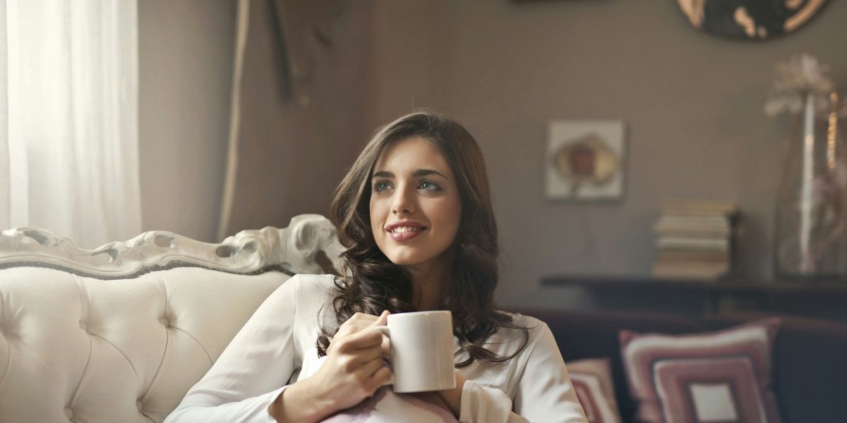 egy nő teát iszik bögréből a kanapén