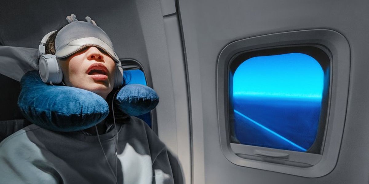 Repülőgépen szemmaszkkal alvó nő az ablak mellett