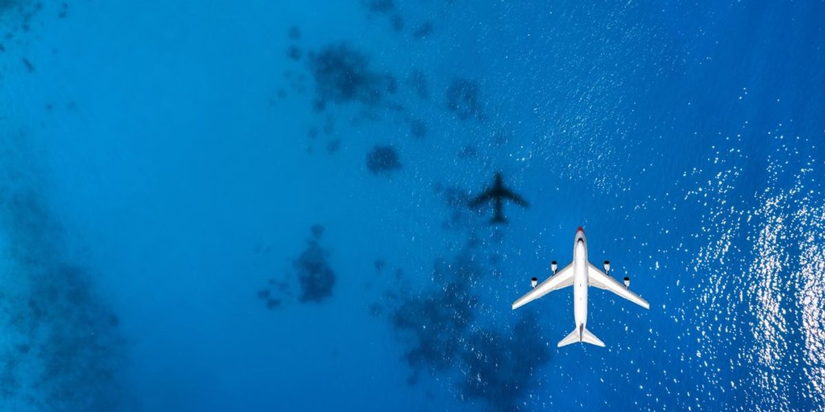 Kék tenger felett repülő repülőgép felülnézetből