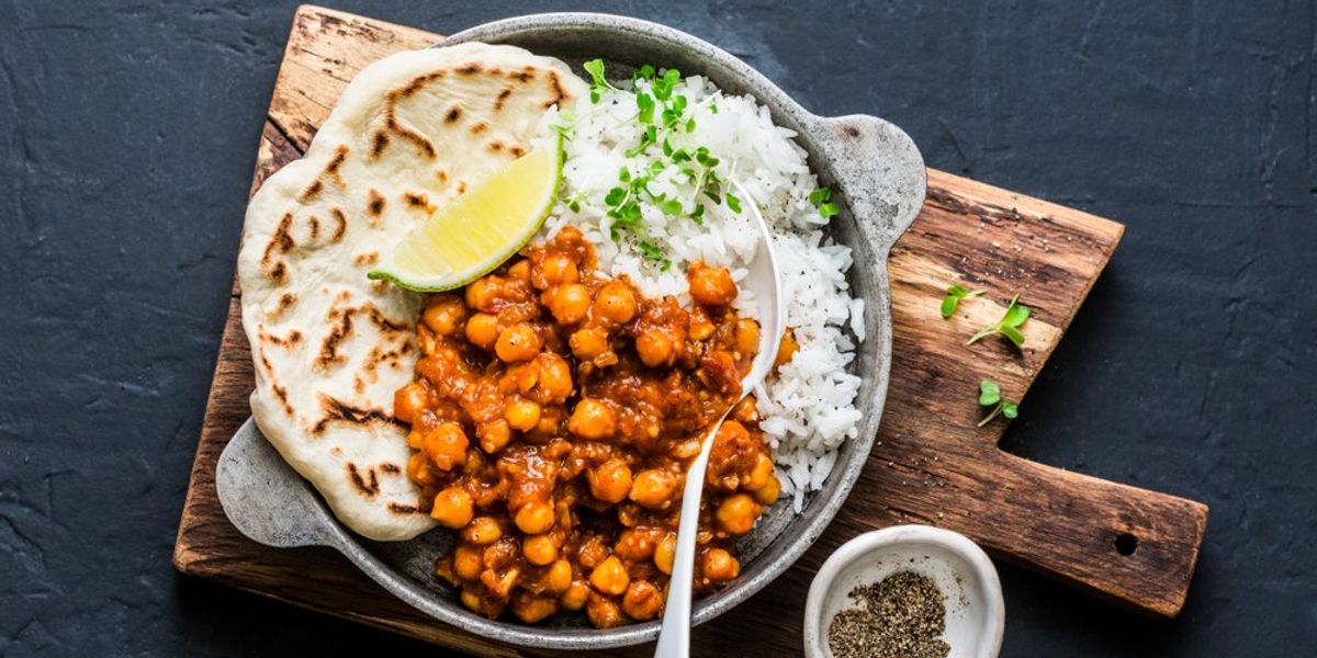Indiai fűszeres csicseriborsó curry rizzsel és naan kenyérrel serpenyőben