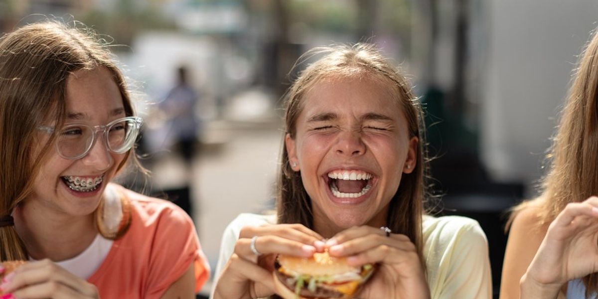 gyerekek nevetnek miközben hamburgert esznek