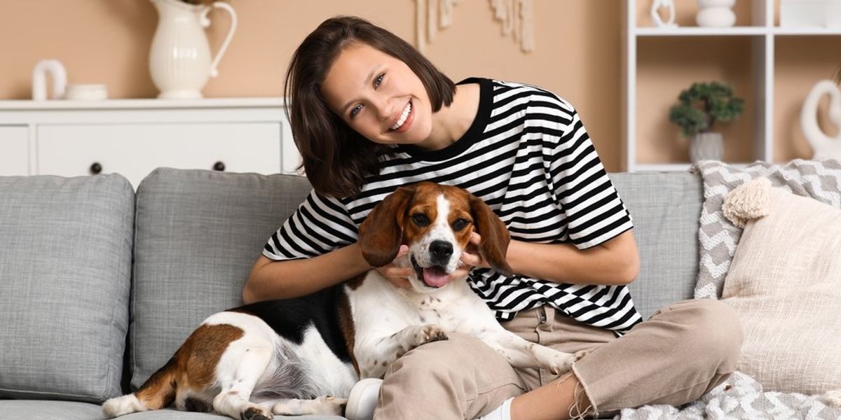Fiatal nő és Beagle kutyája a kanapén