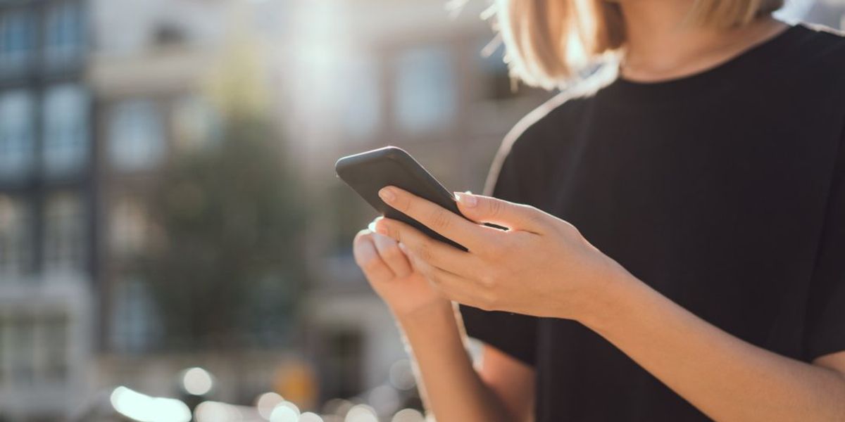 Fiatal lány a telefonját nézi