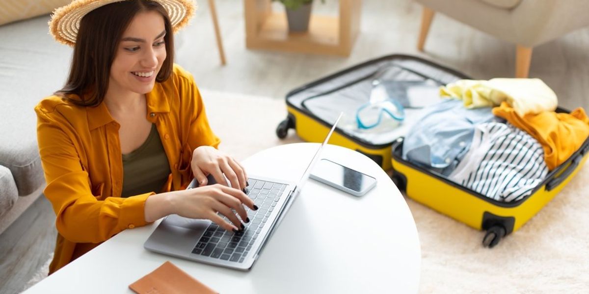 egy nő repülőjegyet vesz a laptopján