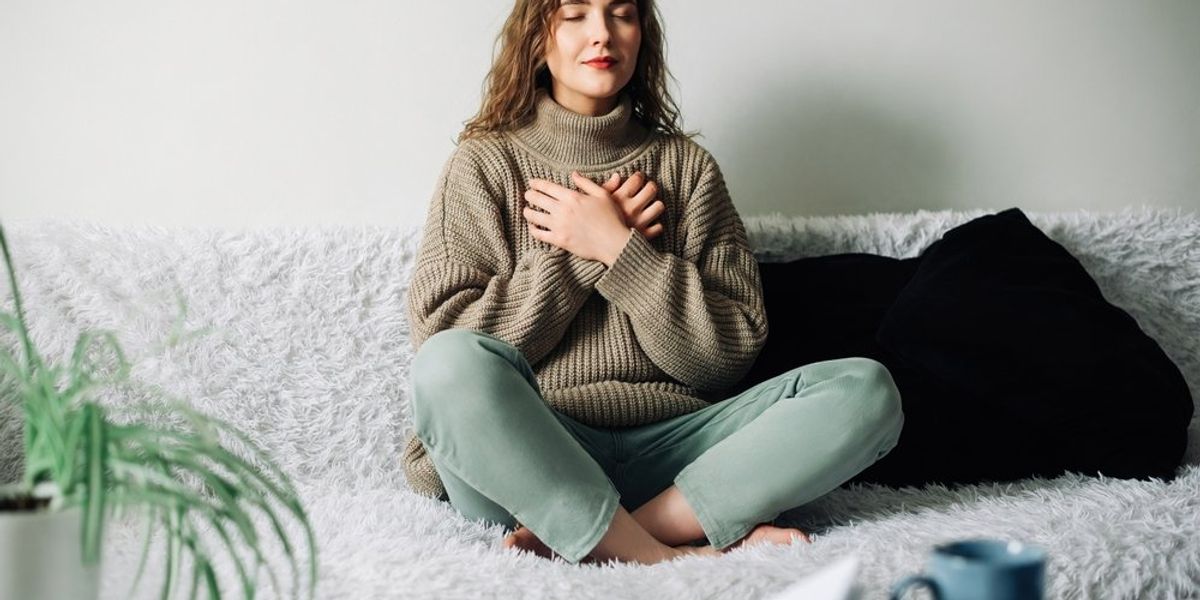 egy nő meditál a kanapén ülve