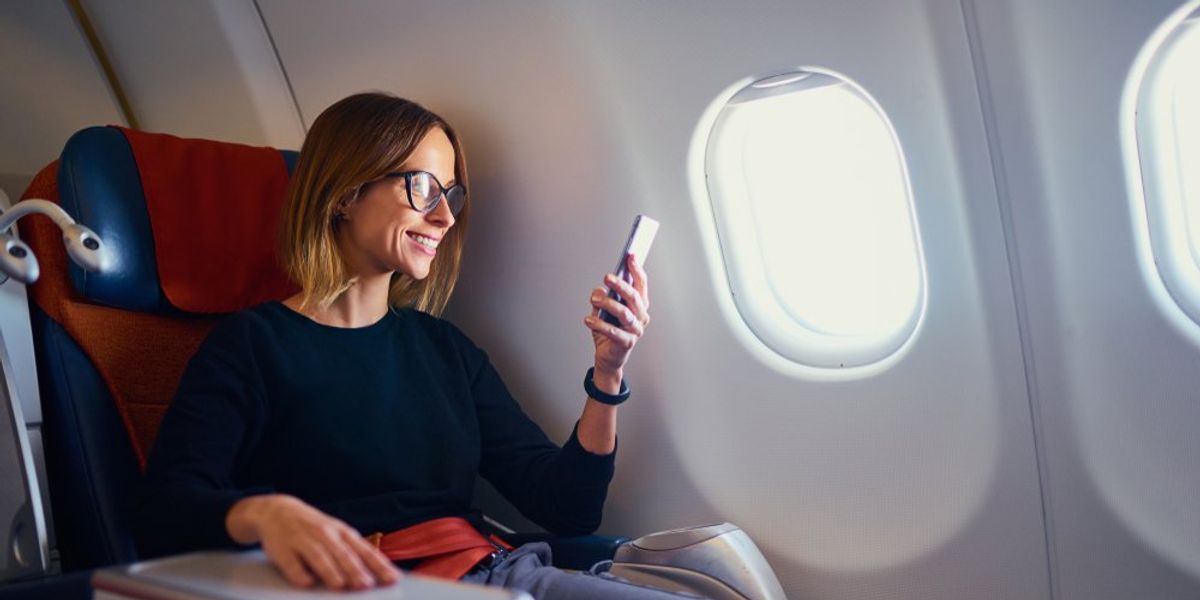 egy nő a repülőgépen telefonozik